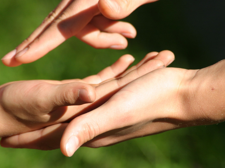 Eine menschliche Hand greift in eine andere und verdeutlicht den Wunsch nach Verständigung